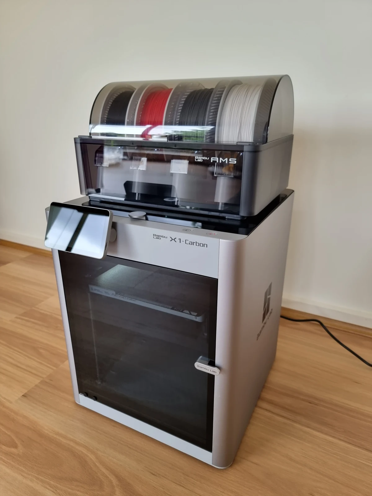 Real photograph of a Bambu Lab X1 Carbon with AMS and filament spools
